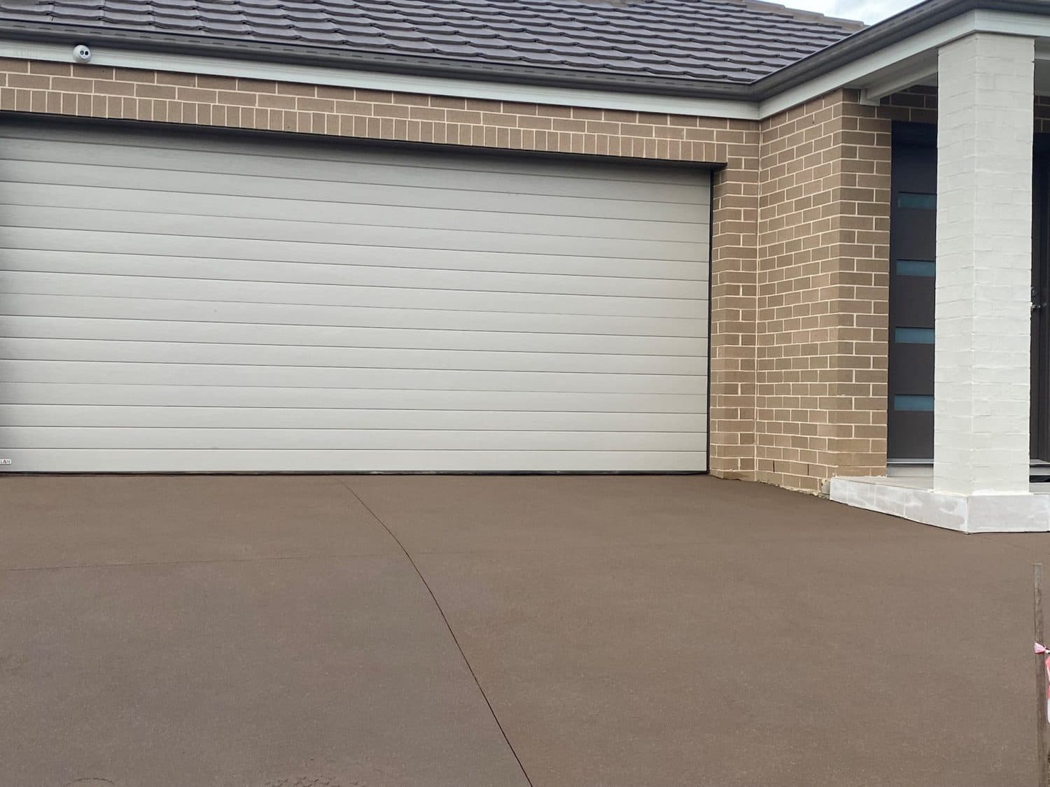 Brown resurfaced driveway in Austral matched to the home's brickwork